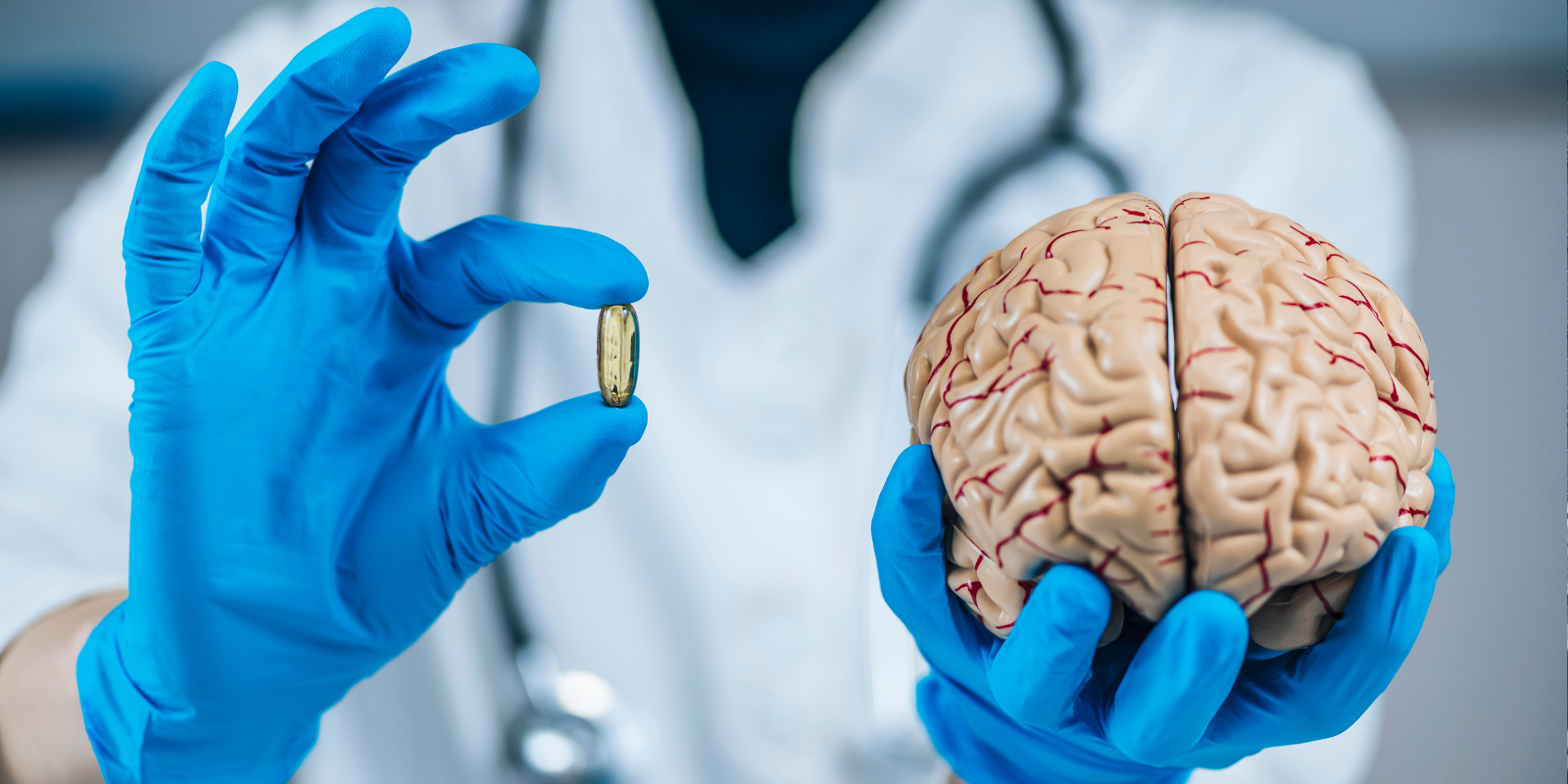 Doctor holding brain model and pill 