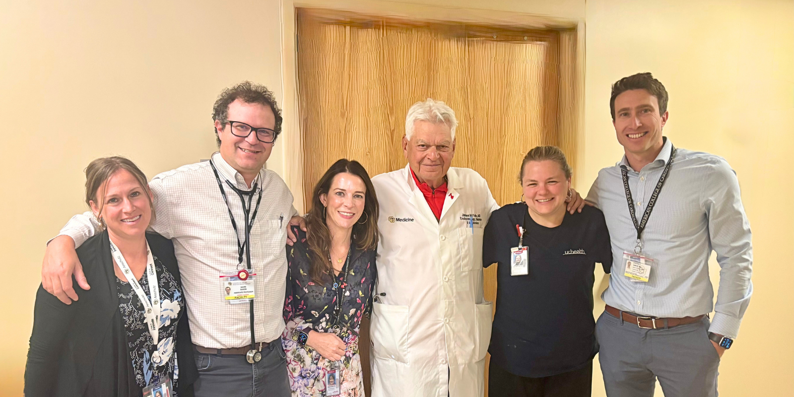 Six health care workers smile together for a photo.