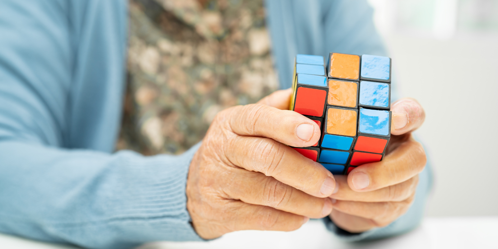 Image of an older adult holding a Rubik's Cube.