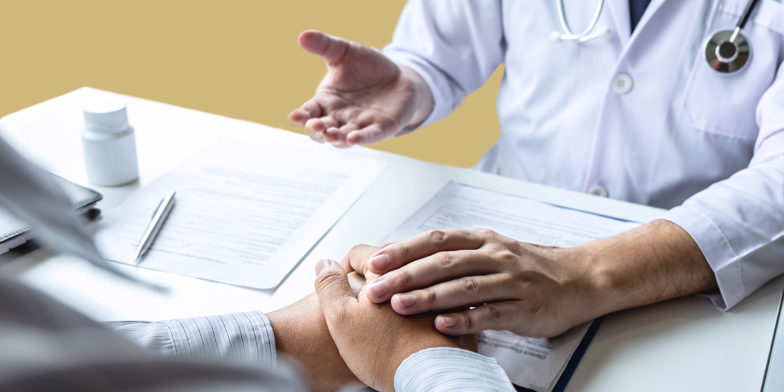 A doctor holding the hand of a patient.