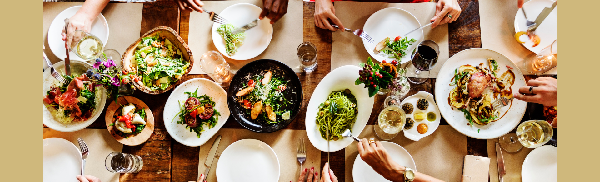 A group of people eating from a variety of different food items on a table.