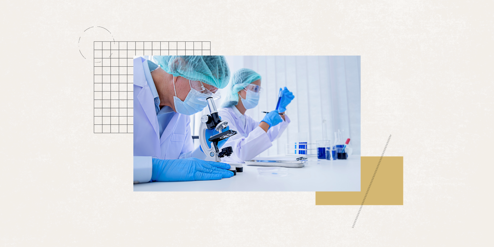 Two researchers wearing white coats, scrub caps, and blue gloves work in a research lab.