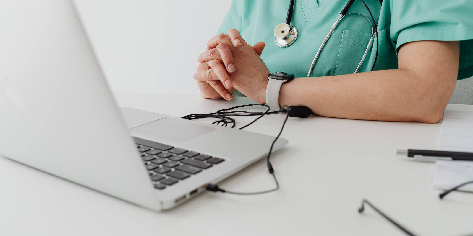 Health care worker sitting beside a laptop.