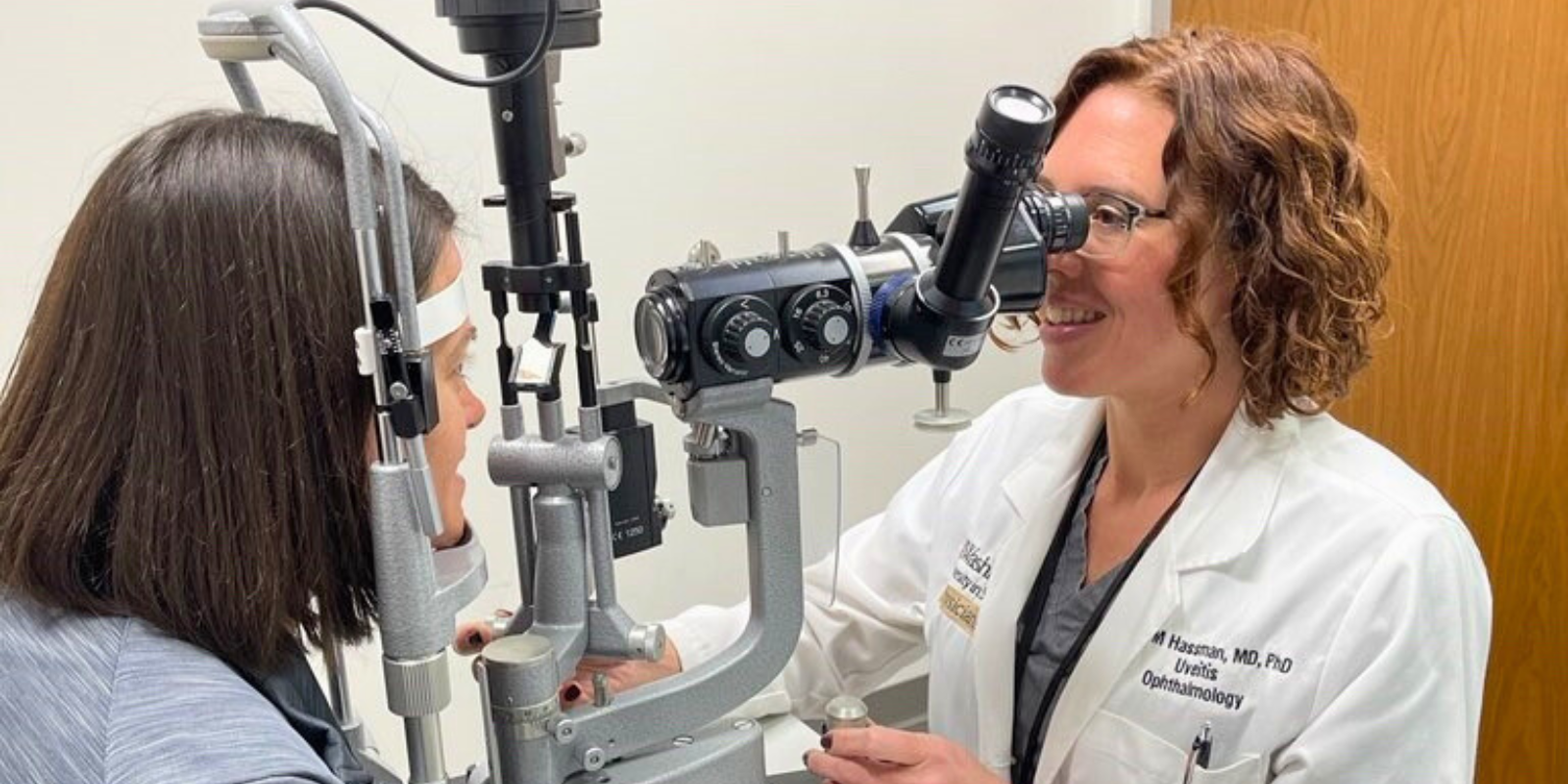 Lynn Hassman, MD, PhD, conducting an eye exam on a patient.