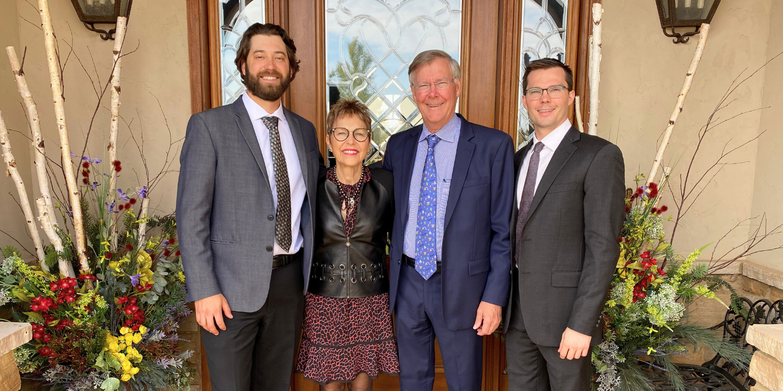 Four members of the Slingsby family smile while standing in front of a door.
