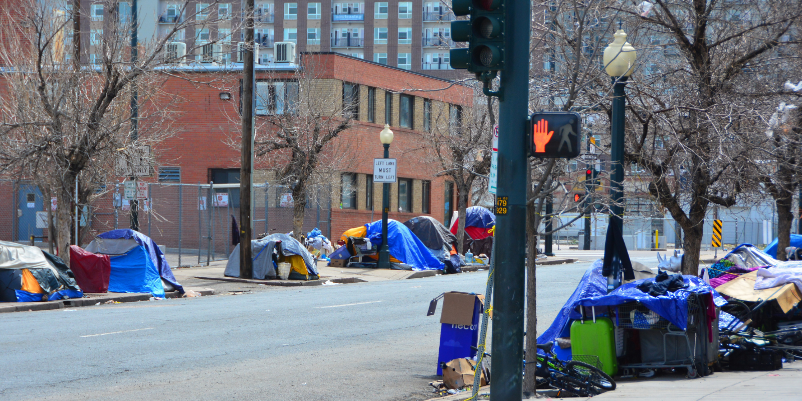 A street in Downtown Denver with a tents on the sidewalk.