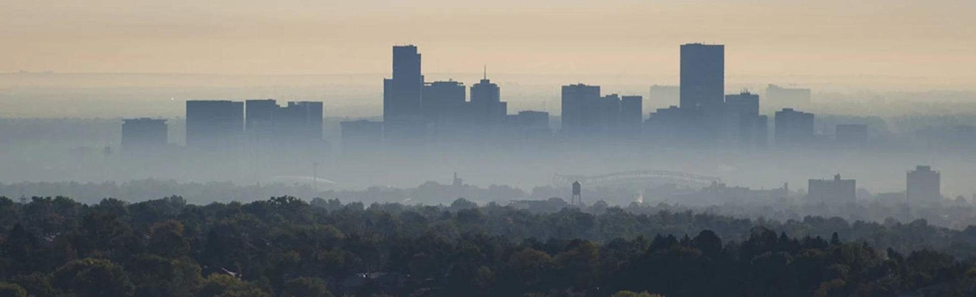 Denver's skyline is shown with early morning pollution haze blanketing the buildings. 