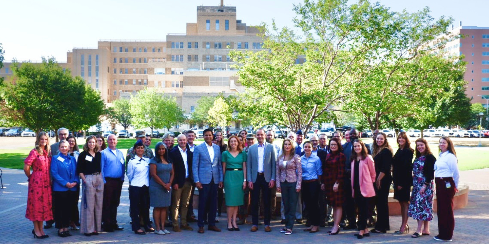 Attendees of the summit pose for a group photo in front of the Fitzsimons building. 