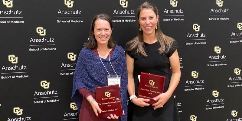 Photo of Kelsey Walker, MD and Kalina Ehrenreich-Piot, DO holding their awards.