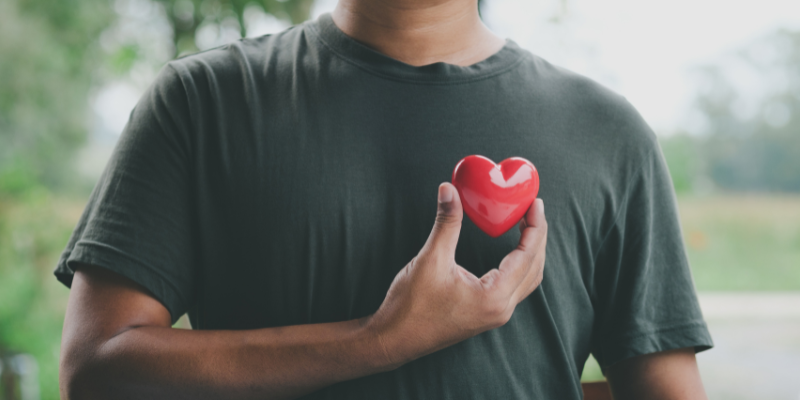 Man holding up a heart to his chest.