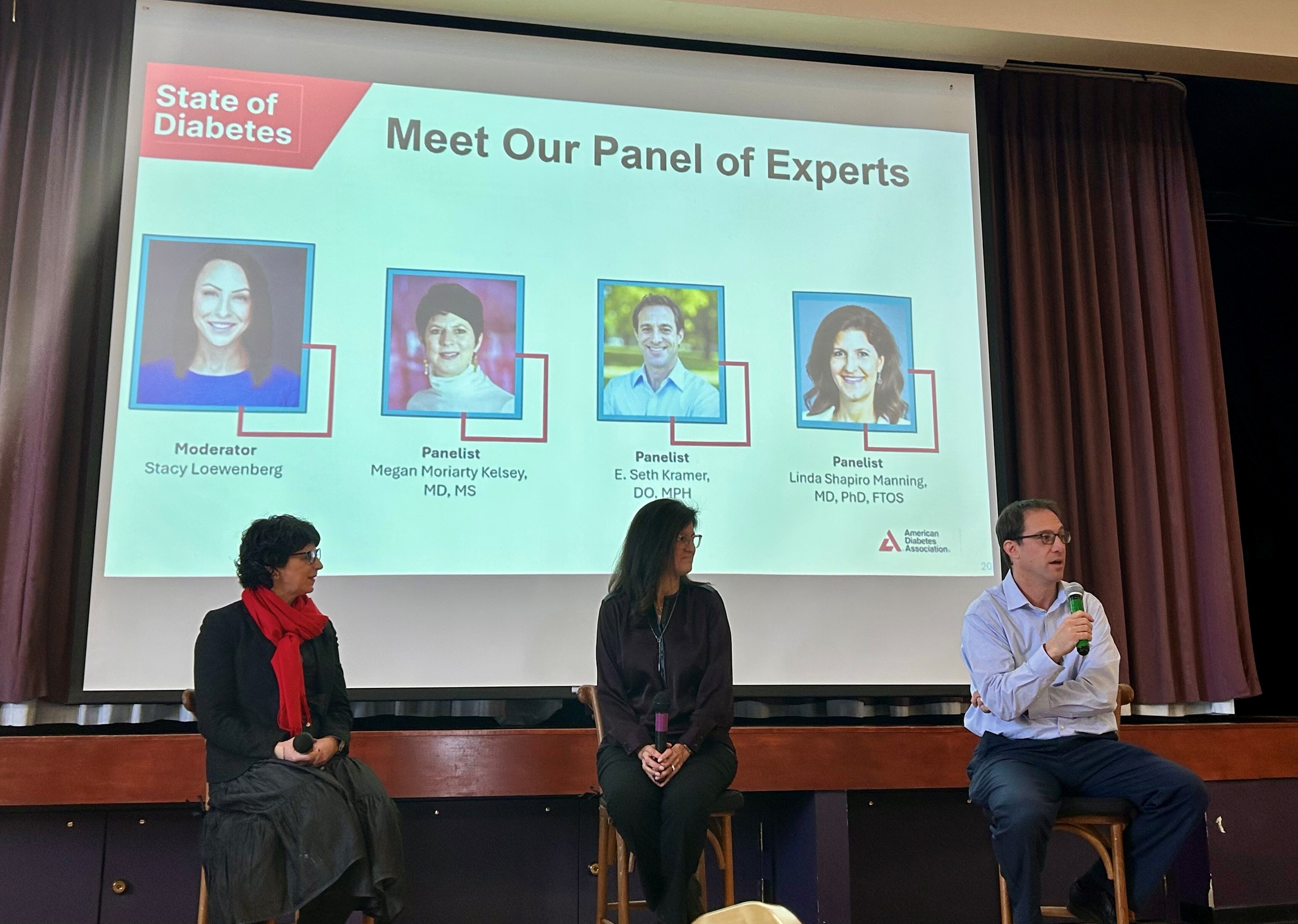 Panelists speaking in front of their presentation screen.