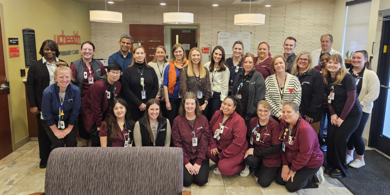 Group photo of physicians and staff in front of the Lone Tree Primary Care check in desk.