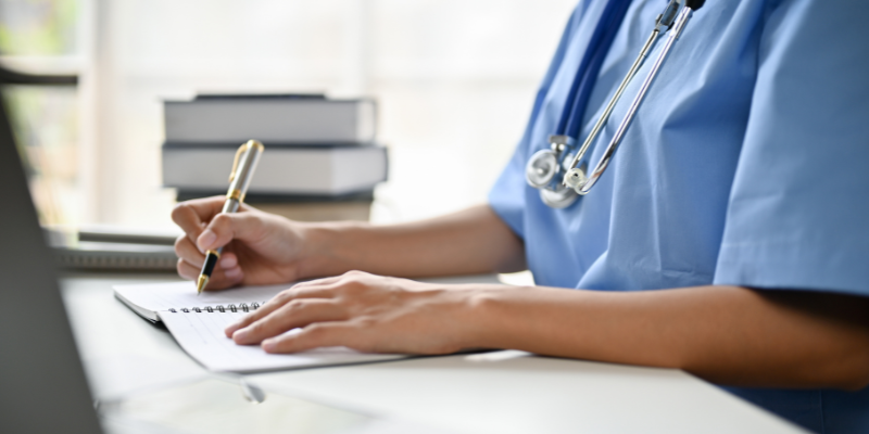 Female Dr. writing notes.