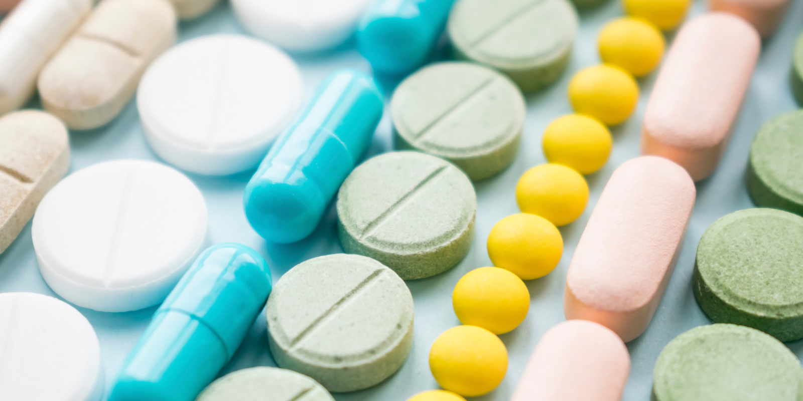 Image of several rows of differently colored medical pills.