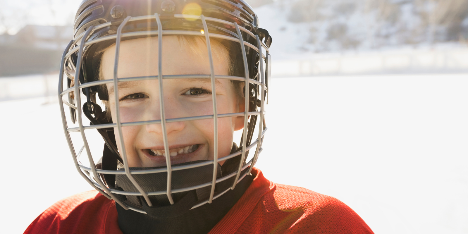 Child smiling in a hockey mask 