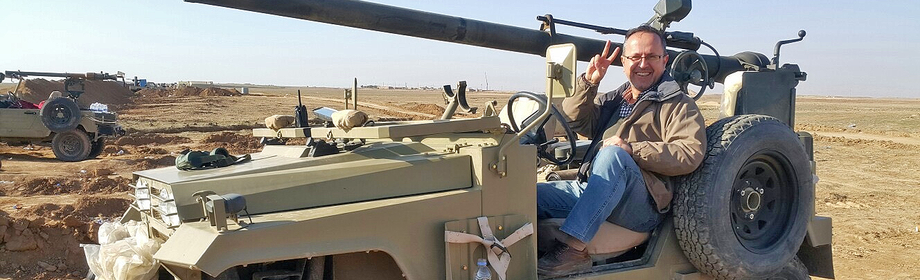 Mohammed Al-Musawi, MD, seated in Iraqi military vehicle