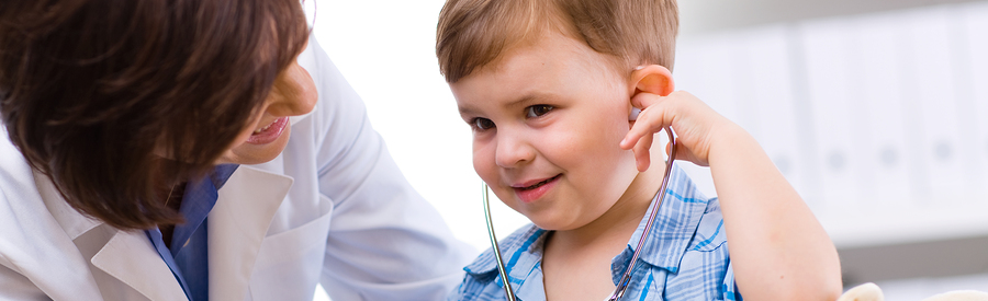 Child listening to stethoscope with doctor