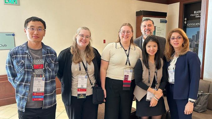 Yanjun Gao, PhD, with colleagues at AMIA 2024