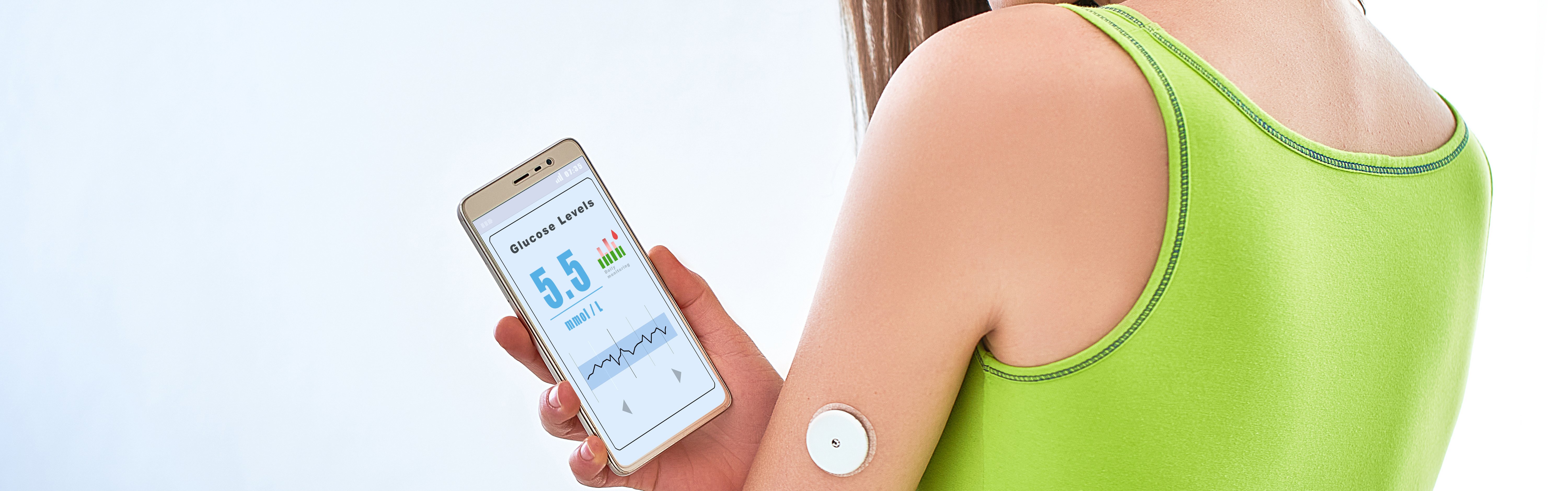 young woman holds glucose monitor