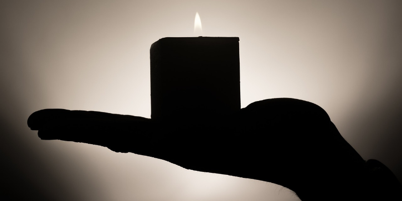 Shadow of a hand holding a candle