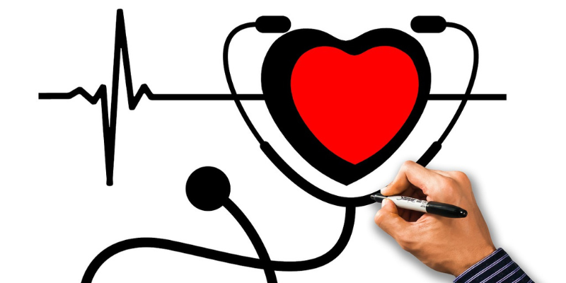 Image of a drawn heart in the middle of a stethoscope on a white board next to a marker and hand