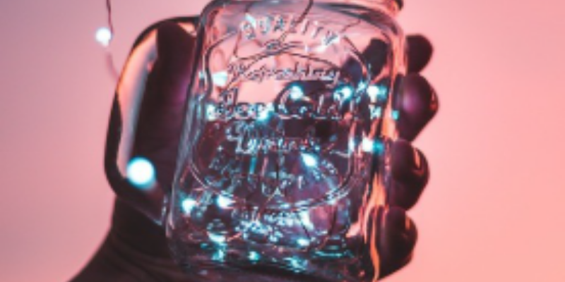 Jar filled with lights on a pink background