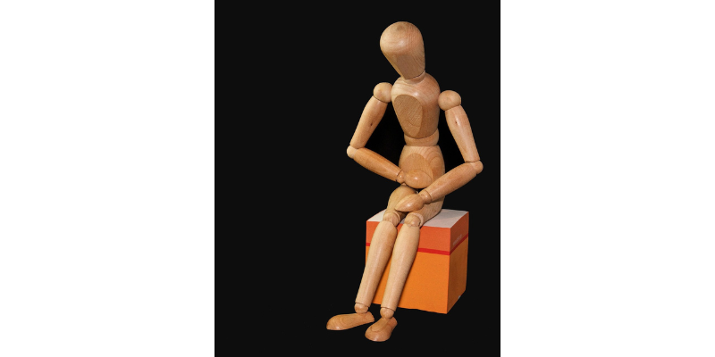 Wooden person on an orange box