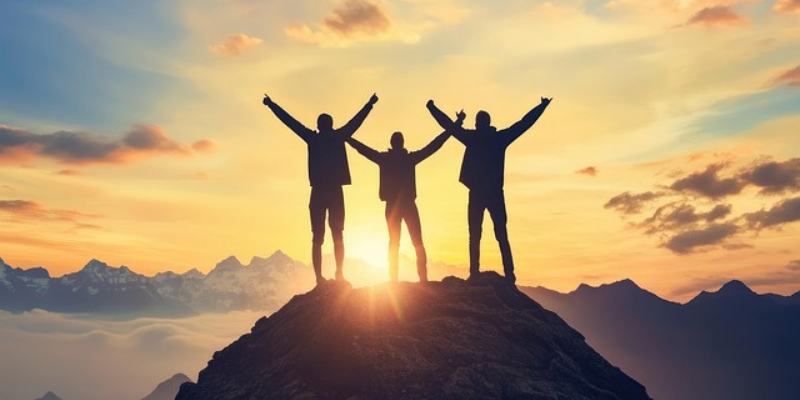 Shadows of three people in front of sunrise