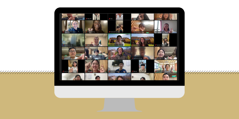 A computer screen shows faces of students holding hearts with their hands on Zoom