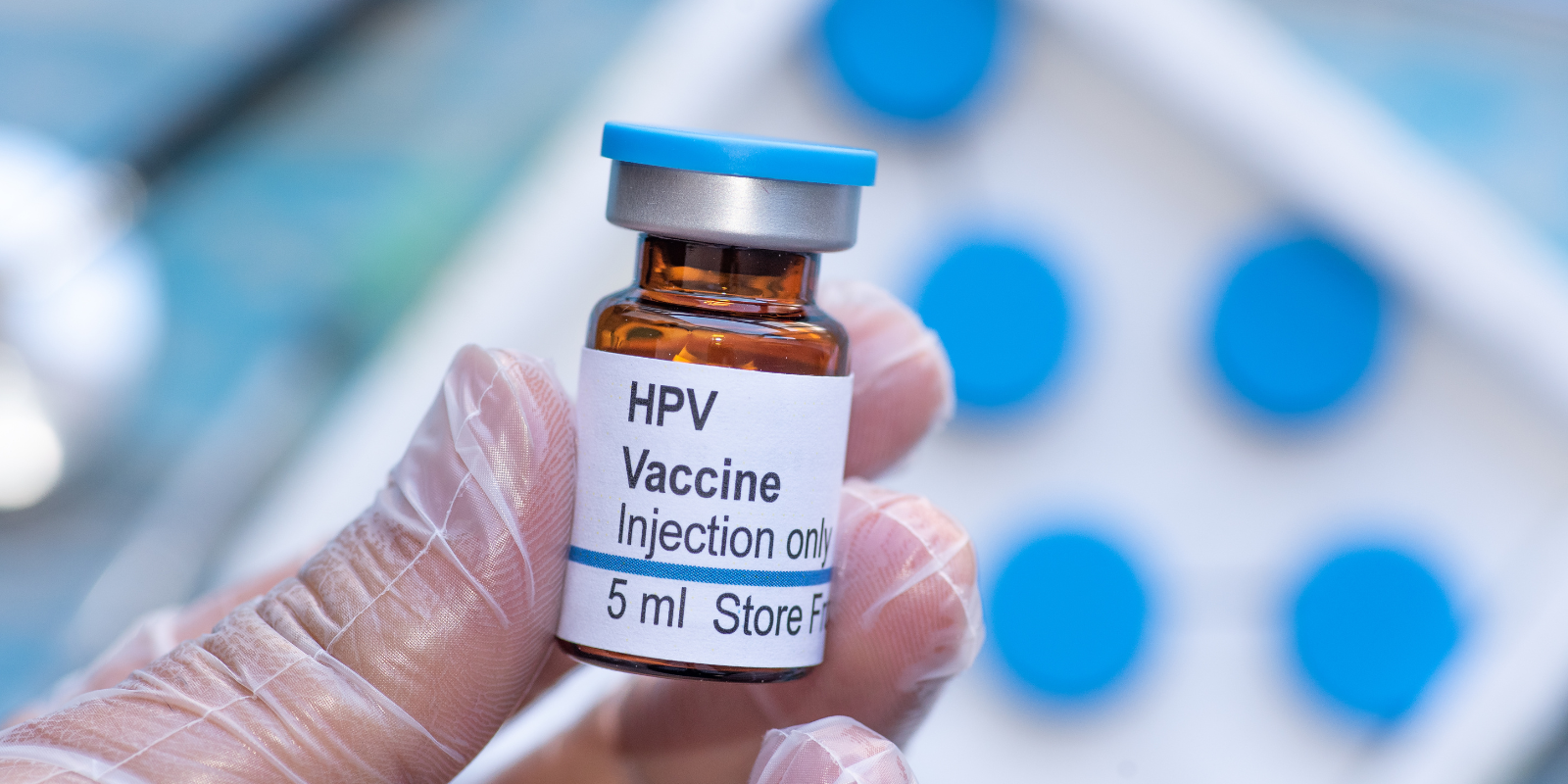 hand holding vial of HPV vaccine