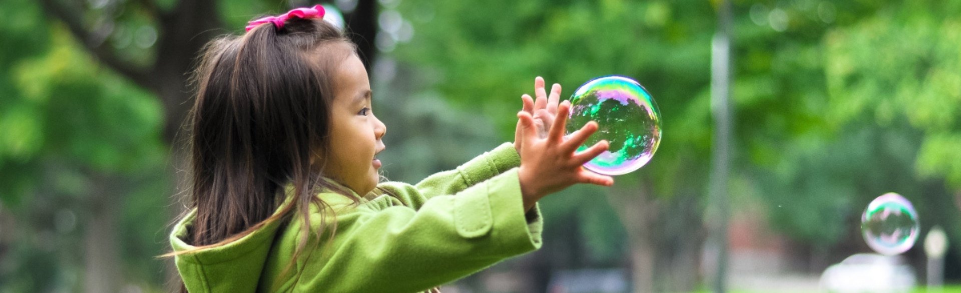 Little girl grabbing bubble