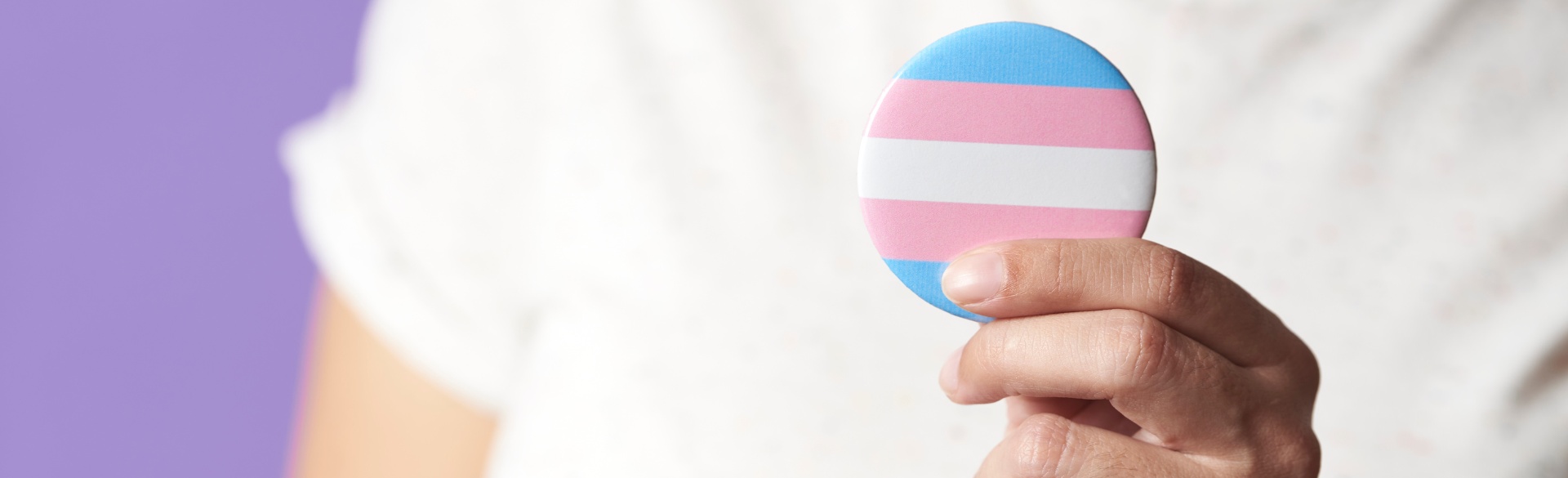 Person holding transgender flag button