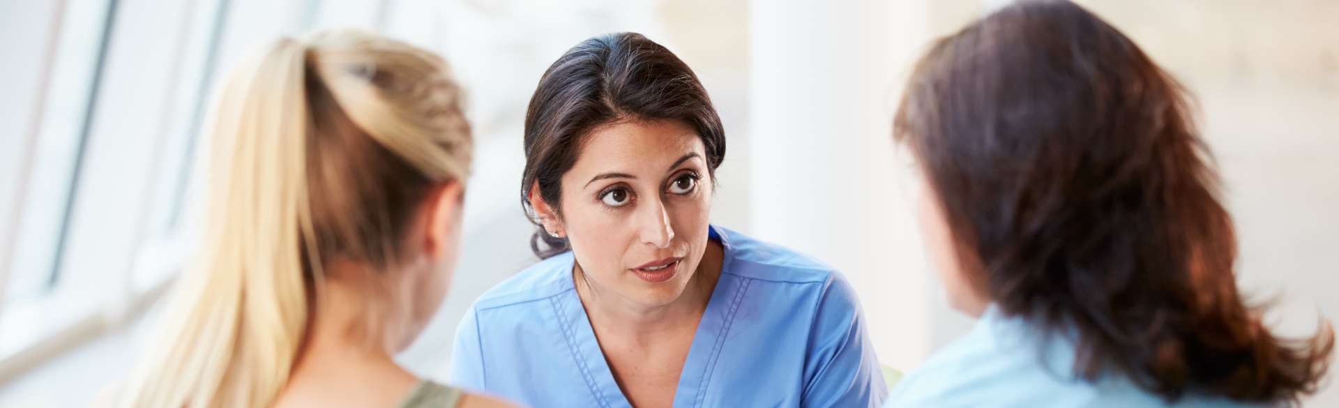 Medical professional talking to two people