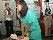 Comilla Sasson, MD, demonstrates the proper technique for CPR on a simulator dummy