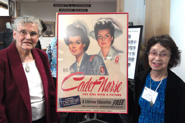 Thelma Robinson and Helen Nakagawa Budzynski stand next to Cadet Nurse poster