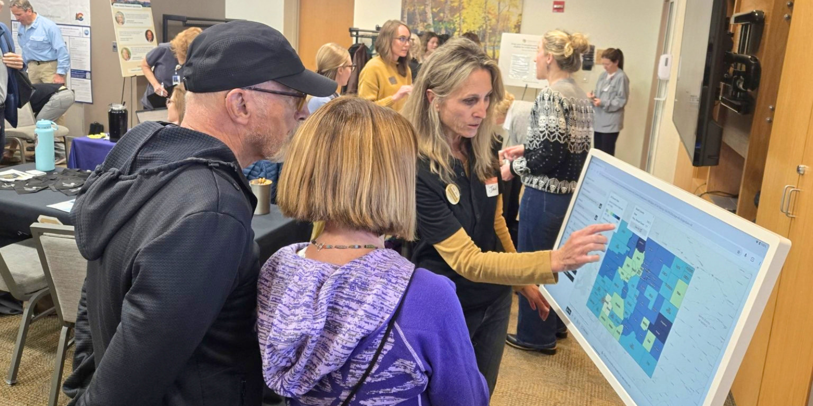 Jan Lowery, PhD, right, shows Steamboat Springs residents Jay Free and Carol Fugate information from the CU Anschutz Cancer Center’s ECCO mapping system during the Research Roadshow Oct. 17, 2025 at UCHealth Yampa Valley Medical Center