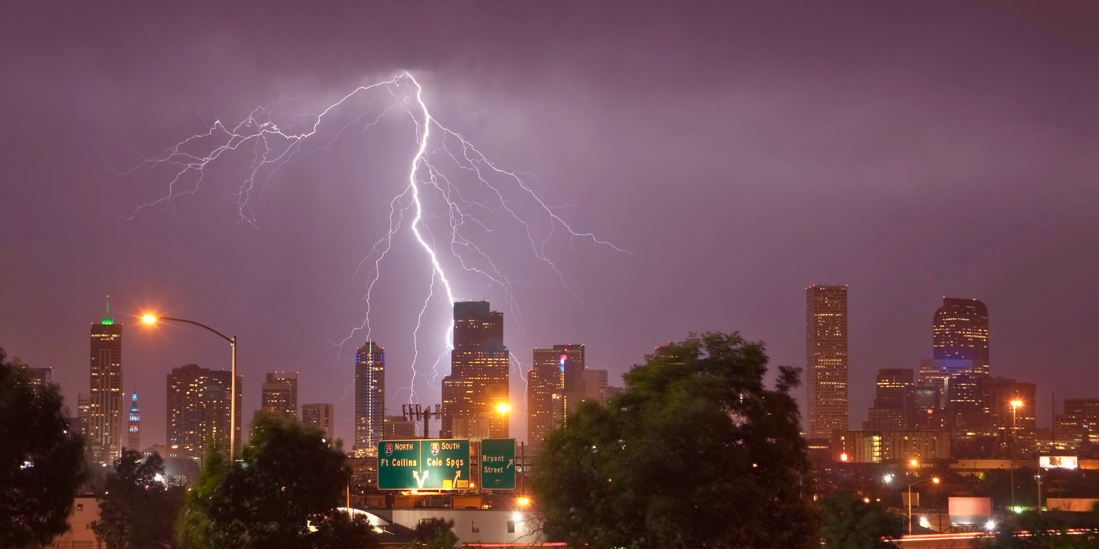 Lightning is seen over the Denver skyline at night.