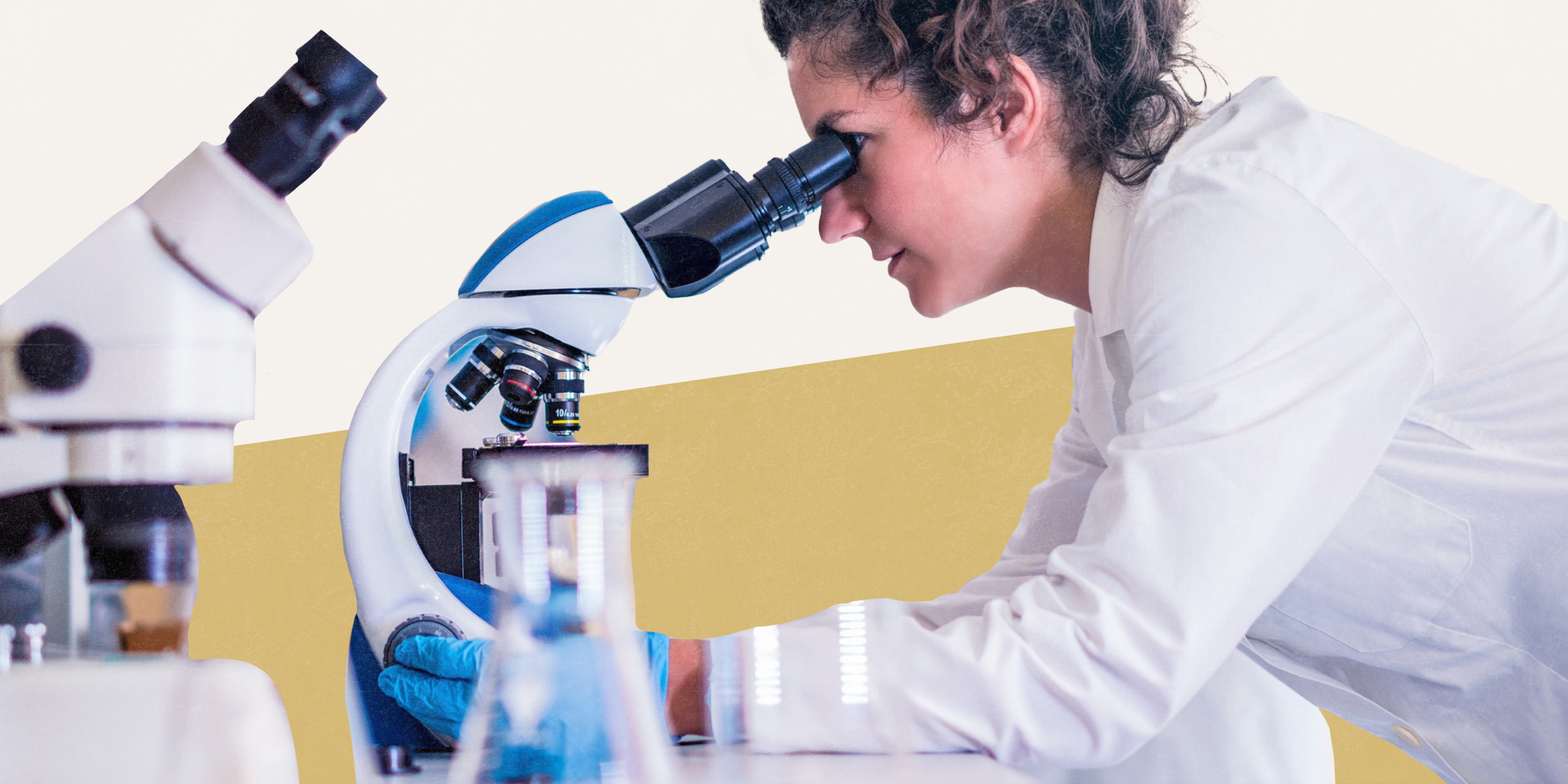 A researcher peers into a microscope, with a stylized white and gold background behind them. 