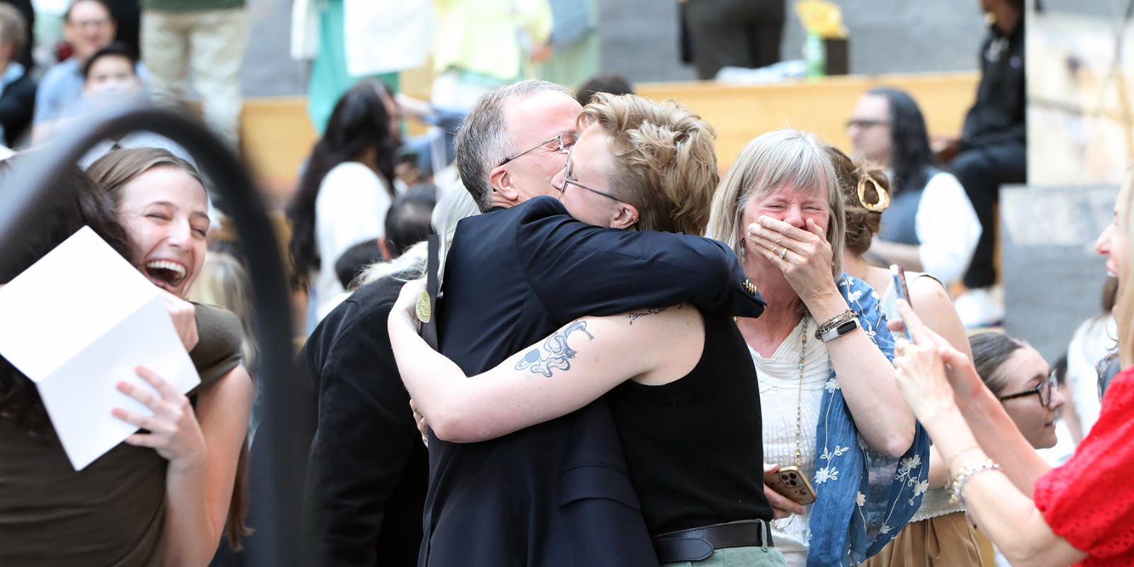 Fourth-year medical student Ry Hemond (center) is congratulated as students open their envelopes to learn their residency destination at the Match Day 2026 celebration on March 20, 2026.