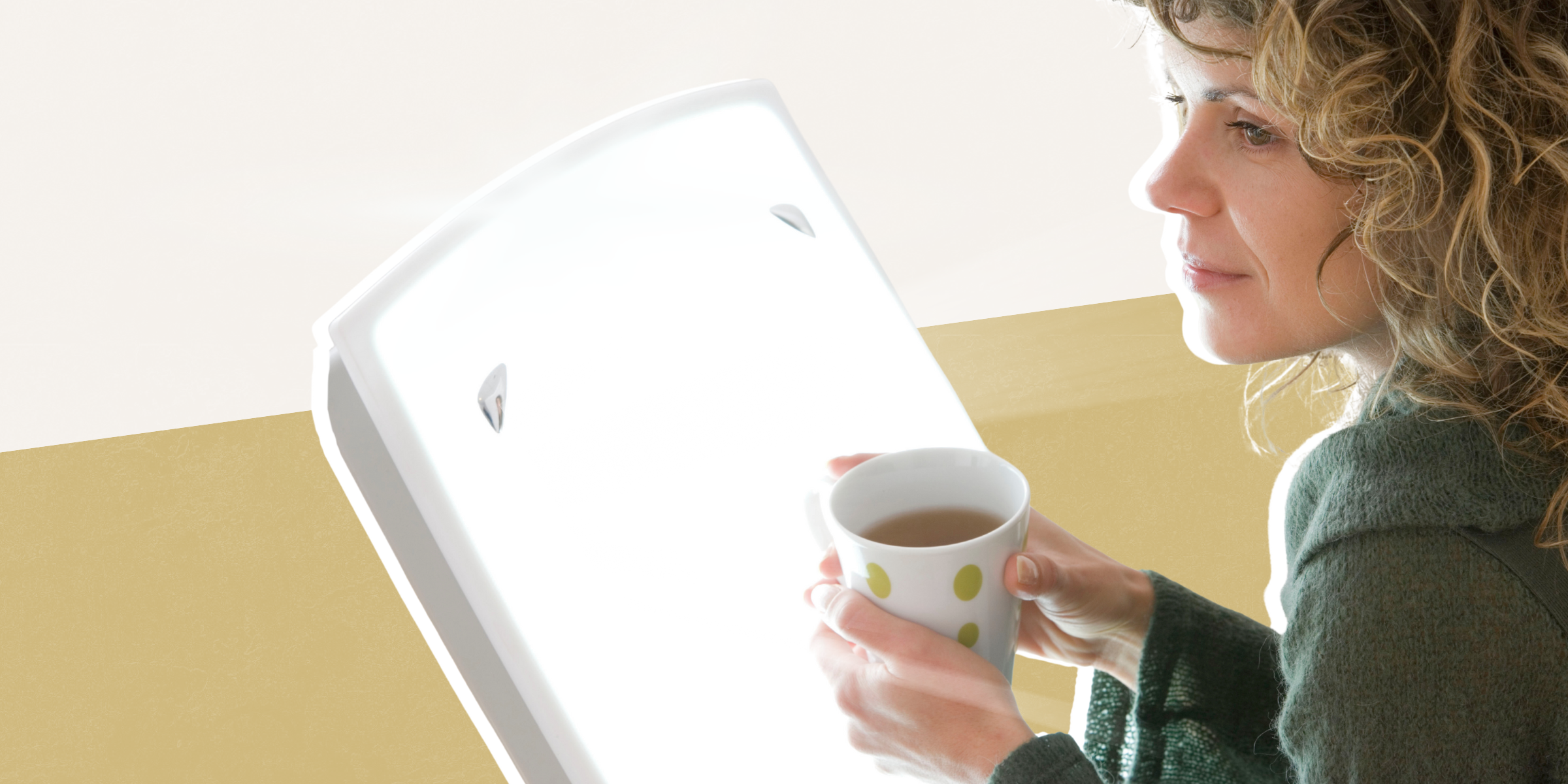 Photo of a woman receiving light therapy while drinking coffee.