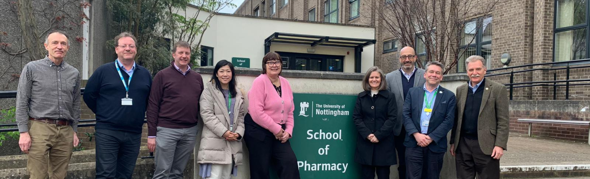 A team of pharmacists and researchers post in front of a sign saying University of Nottingham School of Pharmacy