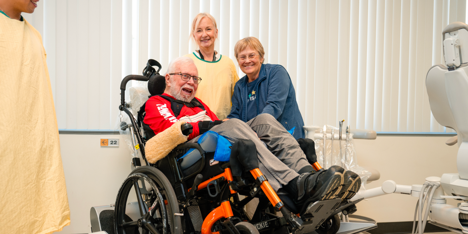 Dental patient uses wheelchair lift, with wife and dentist in the clinic