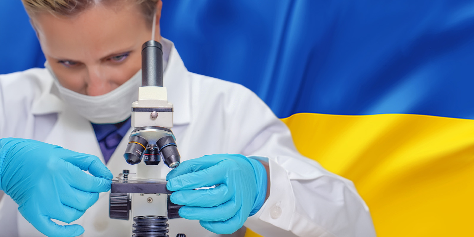 A doctor uses a microscope with a Ukrainian flag in the background.