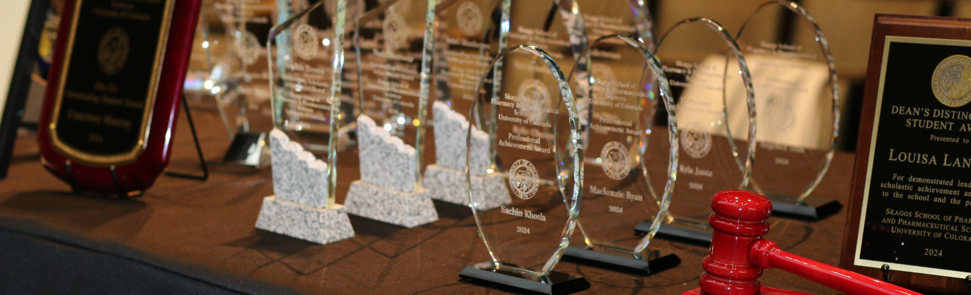 A table with a gold cloth covering, filled with awards.