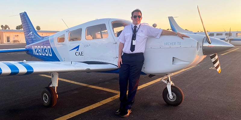 Pilot Brynn Lansford stands next to a Piper Archer PA-28 airplane, in which he logged more than 1,000 hours of training flight time.