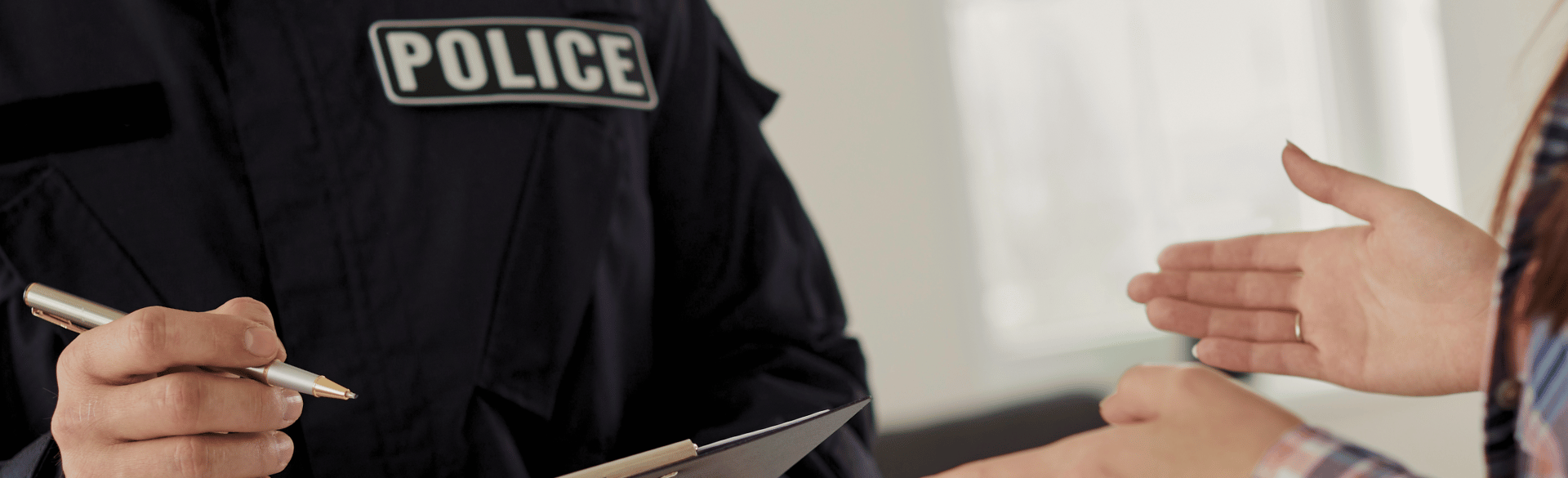 police officer taking notes for a report from a woman