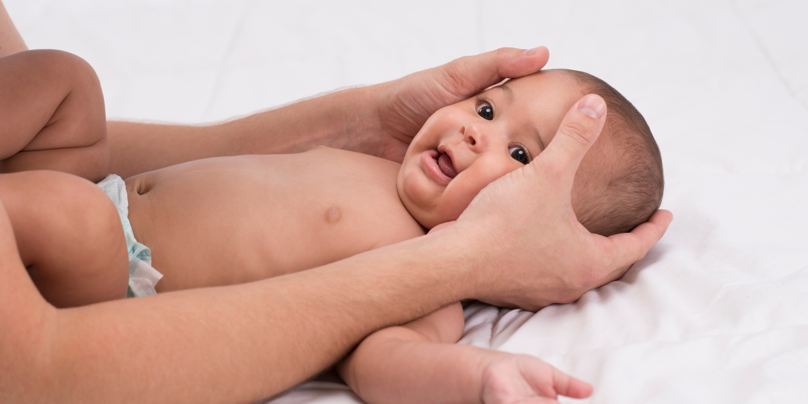 Hands cradling a baby's head