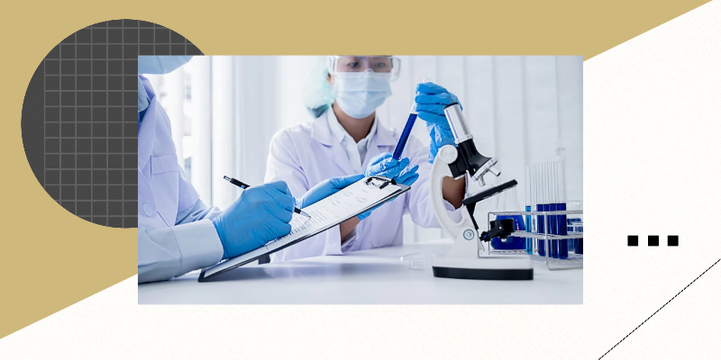 two medical researchers, one with a laptop looking at data, the other with a microscope