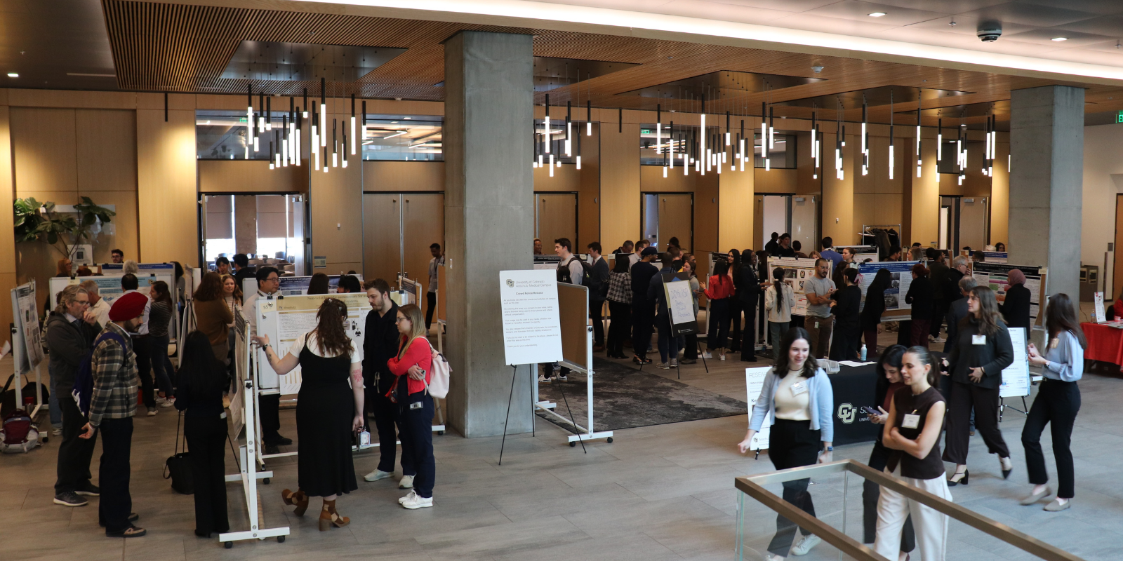 students faculty and staff mingle around poster presentation competition