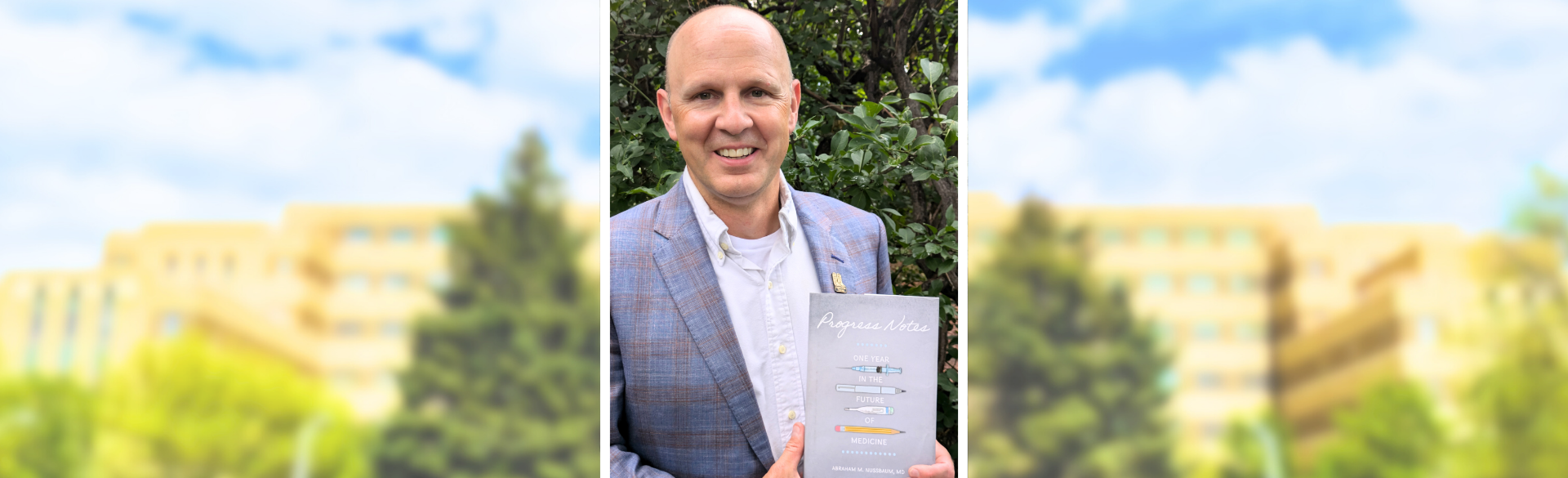 Abraham Nussbaum, MD, holding his book, "Progress Notes."